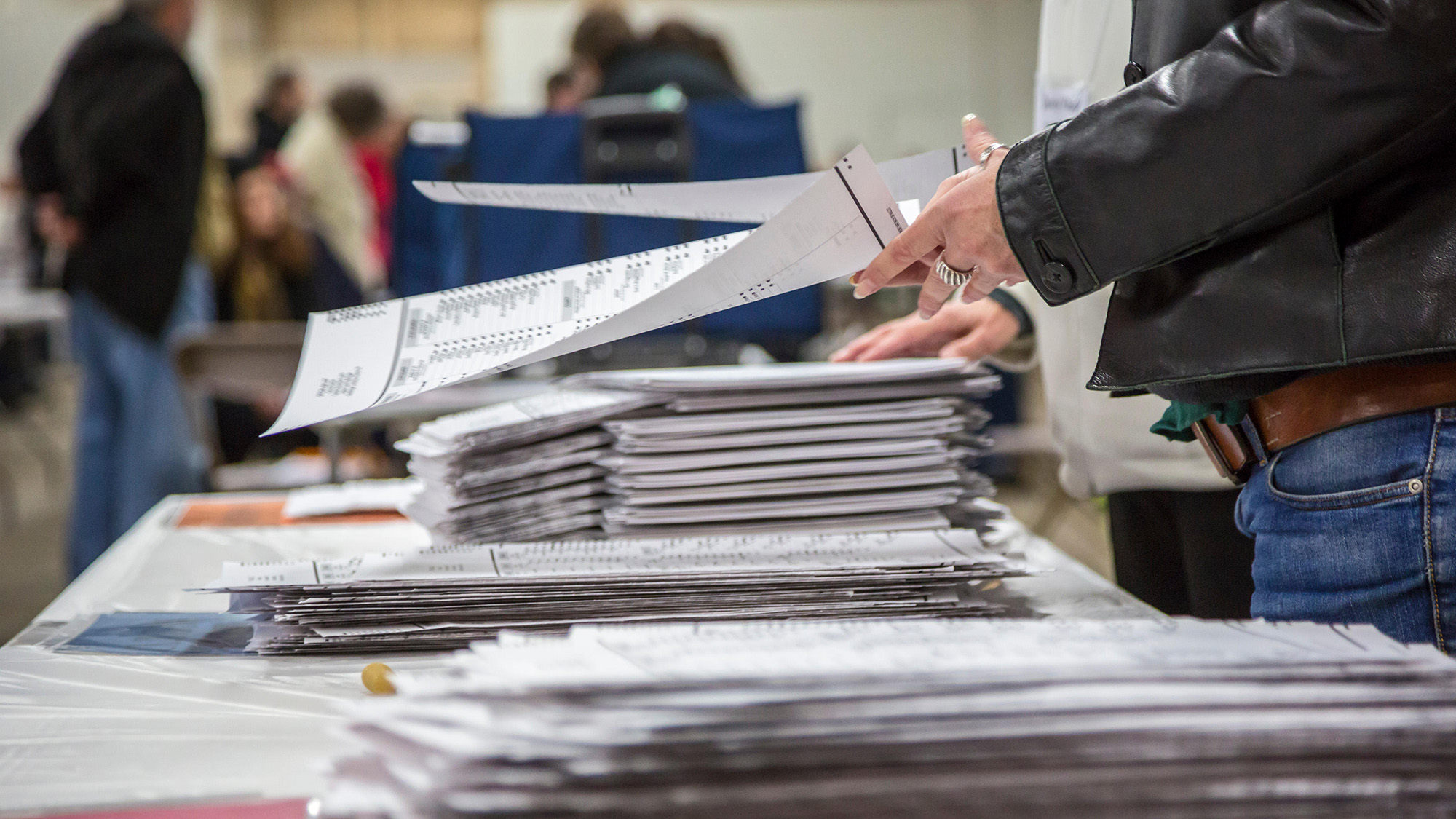 A hand on a ballot during an election.